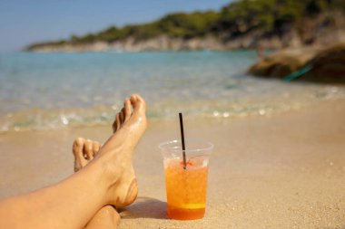 Woman on the beach, drinking coctail in the water, enjoying summer. Halkidiki, Greece