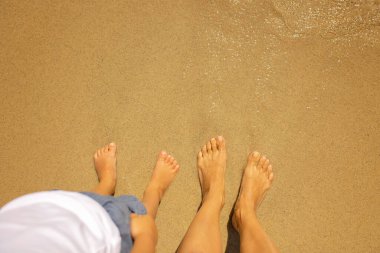 Child, cute boy, playing on the beach in the sand, enjoying summer, number sign