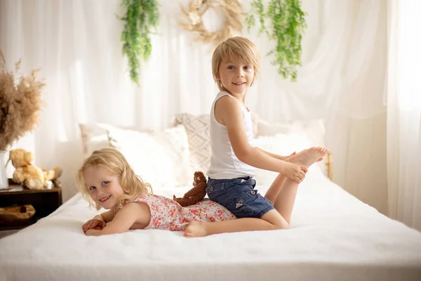 かわいい甘い幼児の子供たち ベッドの上で足をくすぐる 笑って笑顔 子供っぽいいたずら — ストック写真