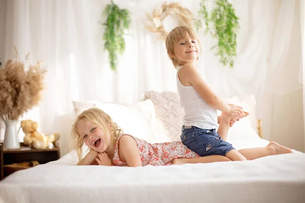 かわいい甘い幼児の子供たち ベッドの上で足をくすぐる 笑って笑顔 子供っぽいいたずら — ストック写真