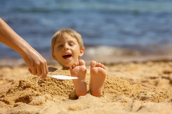 Çocuk Kumsalda Ayaklarında Tüyle Gıdıklanan Kardeş Çocuk Kumla Kaplı Gülümseyen — Stok fotoğraf