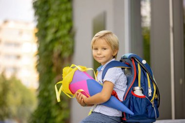 Cute blond child, boy with candy cone on first school day in Czech Republic, old German tradition that what transfer to Czzech as well