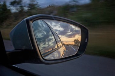 Araba aynasında gün batımı, doğanın yansıması, yakın çekim.