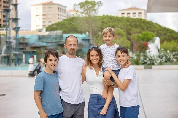 Beautiful portrait of happy family, walking in Monaco, beautiful white terrace next to the beach