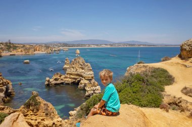 Çocuklar, Benagil, Portekiz 'in tadını çıkarıyorlar. Benagil Mağarası, Algar de Benagil 'in içinde, Algarve, Lagoa' daki ünlü deniz mağarası. Mutlu aile kano gezisinde.