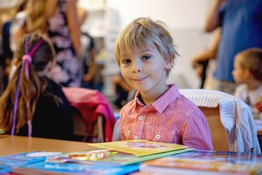 Birinci sınıf öğrencisi için okulda ilk gün, okula başlayan çocuk, öğretmen için çiçek getiriyor, aile üyeleri de onunla gidiyor.