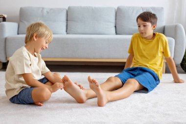 Mutlu pozitif çocuklar, ayaklarınızı gıdıklayarak, birlikte eğlenerek, evde erkek kardeşler birlikte harika bir gün geçiriyorlar.