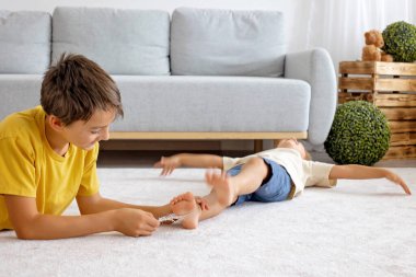 Mutlu pozitif çocuklar, ayaklarınızı gıdıklayarak, birlikte eğlenerek, evde erkek kardeşler birlikte harika bir gün geçiriyorlar.