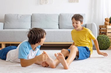 Mutlu pozitif çocuklar, ayaklarınızı gıdıklayarak, birlikte eğlenerek, evde erkek kardeşler birlikte harika bir gün geçiriyorlar.
