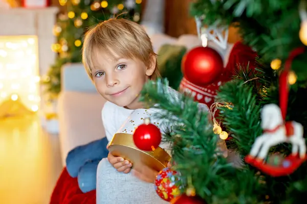 美しいブロンドの子供 若い学校の少年 クリスマスに編まれたおもちゃで装飾された家で遊ぶ — ストック写真