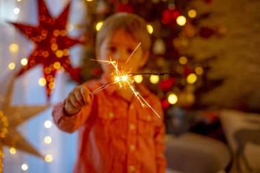 Yeni yıl arifesinde evde maytap tutan çocuk, ailesiyle mutlu bir akşam geçiriyor.