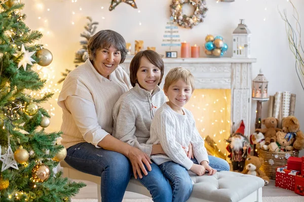 Christmas family picture in cozy home with lights and decoration, grandmother, mother and children