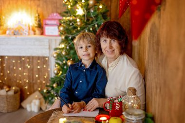 Büyükannem ve çocuğum Noel 'de evdeler, okuyor, mektup yazıyor, yemek pişiriyor, Noel tatilinin tadını çıkarıyorlar.