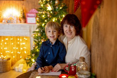 Büyükannem ve çocuğum Noel 'de evdeler, okuyor, mektup yazıyor, yemek pişiriyor, Noel tatilinin tadını çıkarıyorlar.