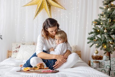 Mutlu bir aile, çocuklar ve anne, sıcak bir Noel stüdyosunda aile fotoğrafları çekiyorlar.