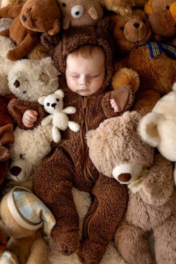 Tatlı yeni çocuk, ayılar içinde bebek çocuk, yatakta oyuncak ayılarla uyuyor.