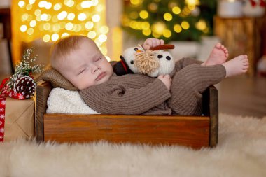 Sevimli yeni doğmuş çocuk, bebek çocuk, Noel 'de anne ve babasıyla evde, ilk Noel tatilinin tadını çıkarıyorlar.