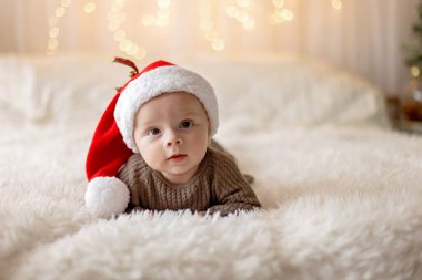 Sevimli yeni doğmuş çocuk, bebek çocuk, Noel 'de anne ve babasıyla evde, ilk Noel tatilinin tadını çıkarıyorlar.