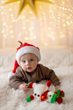 Sevimli yeni doğmuş çocuk, bebek çocuk, Noel 'de anne ve babasıyla evde, ilk Noel tatilinin tadını çıkarıyorlar.