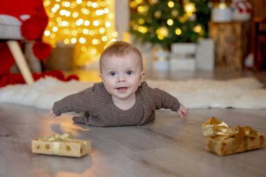 Sevimli yeni doğmuş çocuk, bebek çocuk, Noel 'de anne ve babasıyla evde, ilk Noel tatilinin tadını çıkarıyorlar.