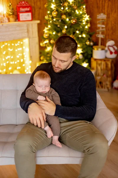 Sevimli yeni doğmuş çocuk, bebek çocuk, Noel 'de anne ve babasıyla evde, ilk Noel tatilinin tadını çıkarıyorlar.