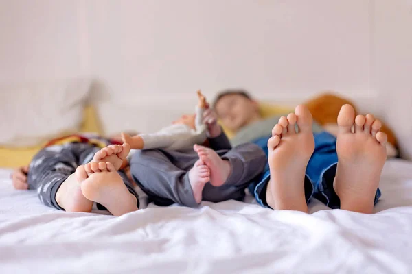 Chlildren feet, little baby boy and older brothers feet, baby lie down in bed in the afternoon