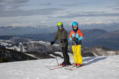 Mutlu aile, çocuklarla kayak tatili, açık havada güneşli güzel hava.