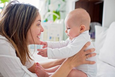 Genç anne ile birlikte, mutluluk aile kavramı, çocuk ve anne bağ oynayan onun yeni doğan bebek çocuk, yatakta yalan