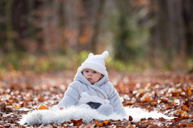 Sonbahar Kış beyaz kürk ormandaki oturan küçük oğlu,