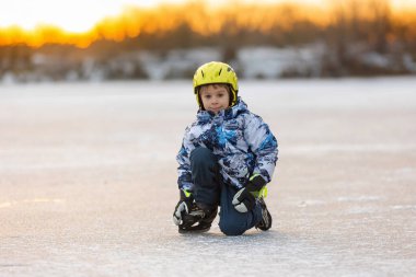 Mutlu çocuk, çocuk, gün boyunca donmuş gölde paten kaymak, dışarıda eğlenmek.