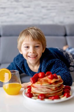 Tatlı çocuk, çocuk, Amerikan gözlemelerini çilek ve muzla yiyor, üstüne şerbet konmuş ve taze portakal suyu içiyor.