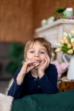 Güzel sarışın çocuk, evlat, anne için tatlı badem kurabiyeleriyle dolu bir kutu tutuyor.