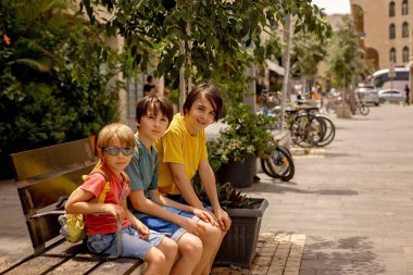 Çocuklu Avrupalı turist ailesi Tel Aviv, İsrail 'i ziyaret ediyor, şehirde gündüz yürüyüşünün keyfini çıkarıyorlar.