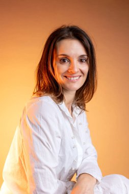 Stüdyoda gülümseyen orta yaşlı beyaz bir kadının portresi.