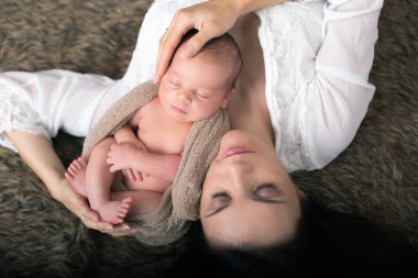 Güzel hassasiyet ile kucaklayan anne ve bakım onun yeni doğan oğlu, yukarıdaki ateş, mutluluk kavramı