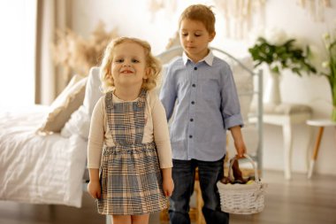 Happy children, siblings, enjoying Easter holiday together, tradition with handmade twig, braided whip made from pussy willow, traditional symbol of Czech Easter