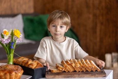 Tatlı anaokulu çocuğu, Paskalya için tatlı brioche ekmeği tutuyor. Badem, fındık ve şekerle pişirilmiş geleneksel tatlı ekmek.