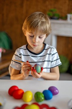 Güzel sarışın çocuk, çocuk, Paskalya için yumurta boyama ve boyama, tatil hazırlıkları.