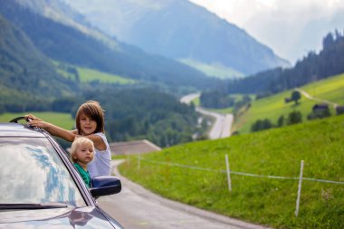 Sevimli çocuk, çocuk bir araba penceresinden bakıyor, doğal dağlara yolda seyahat, yaz