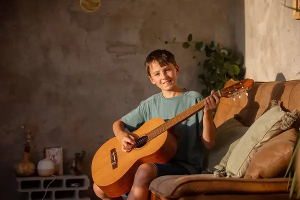 stock image Preteen child, boy, learning how to play acoustic guitar at home, sunny room