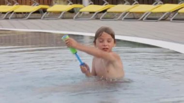 Tatlı çocuk, su parkındaki çocuk, yaz tatilinde eğleniyor.