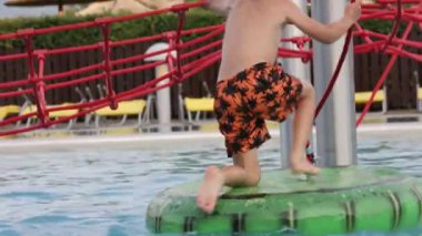 Tatlı çocuk, su parkındaki çocuk, yaz tatilinde eğleniyor.