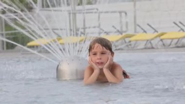 Tatlı çocuk, su parkındaki çocuk, yaz tatilinde eğleniyor.