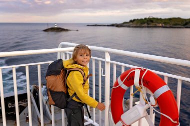 Millet, Bodo ve Lofoten Moskenesoya arasındaki feribot yolculuğunun tadını çıkarın. Yaz mevsimi, gün batımında çocuk ve yetişkinler feribotta.