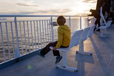 Millet, Bodo ve Lofoten Moskenesoya arasındaki feribot yolculuğunun tadını çıkarın. Yaz mevsimi, gün batımında çocuk ve yetişkinler feribotta.