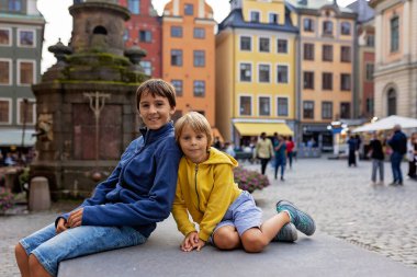 Young preschool child, visiting city of Stockholm with his family, summertime, Sweden clipart