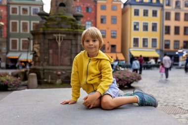 Young preschool child, visiting city of Stockholm with his family, summertime, Sweden clipart