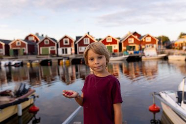 Aile, İsveç 'te küçük bir köy olan Lorudden' i ziyaret ediyor, yaz zamanı. İskandinav kıyı köyü