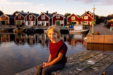 Aile, İsveç 'te küçük bir köy olan Lorudden' i ziyaret ediyor, yaz zamanı. İskandinav kıyı köyü