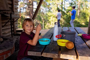 Mutlu çocuk, yol kenarındaki bir bankta yemek yiyor, Norveç 'te aile yemeği yiyor.